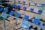 Photograph showing three rows of blue square solar panels. Panels in left portion are labeled 